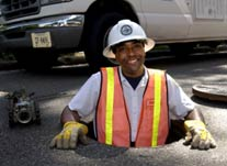 Wastewater worker comes out of manhole